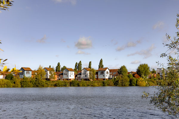 A body of water in front waterfront houses on a sunny day